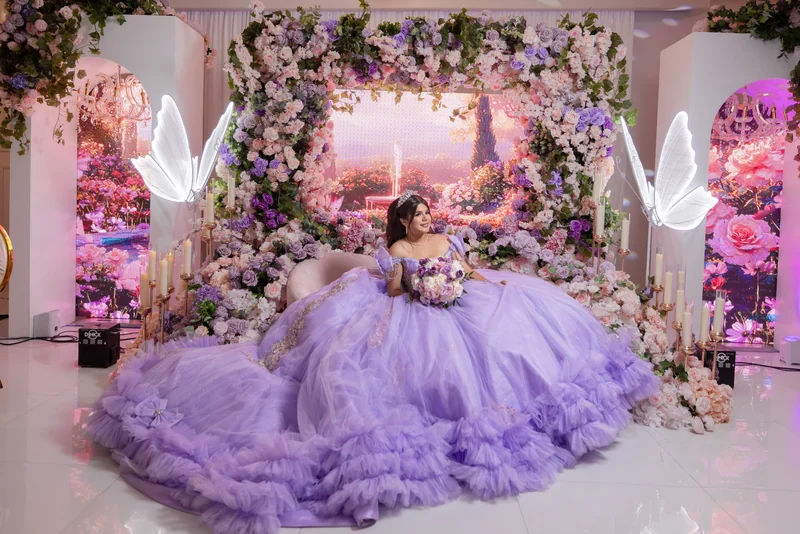 Quinceañera in lavender before a floral arch