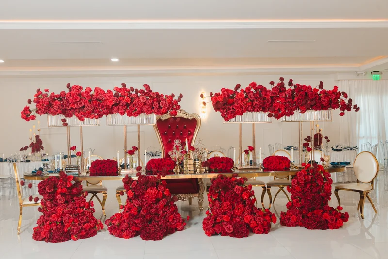 Head table beneath a wall of red roses